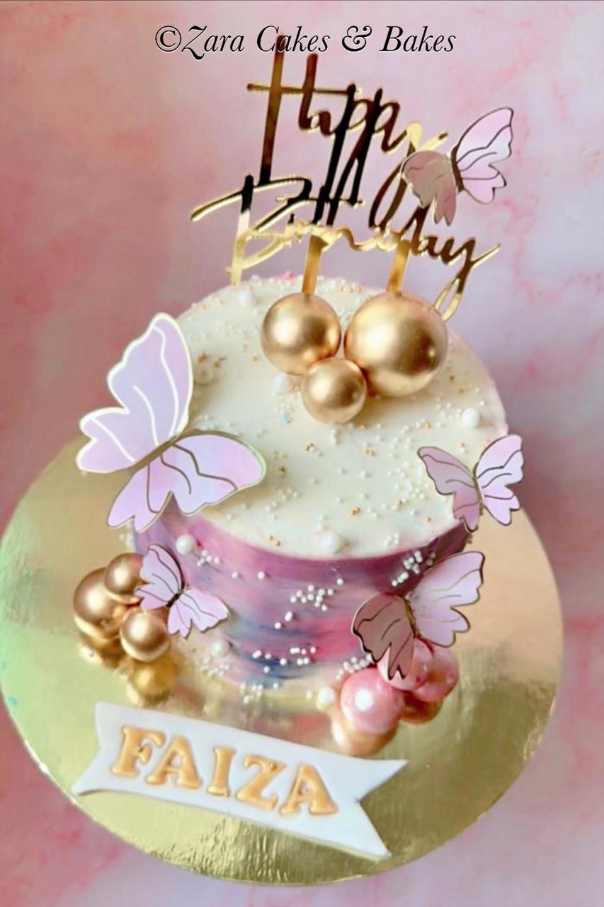 Elegant white and purple watercolor birthday cake with gold balls and pink butterflies for Faiza