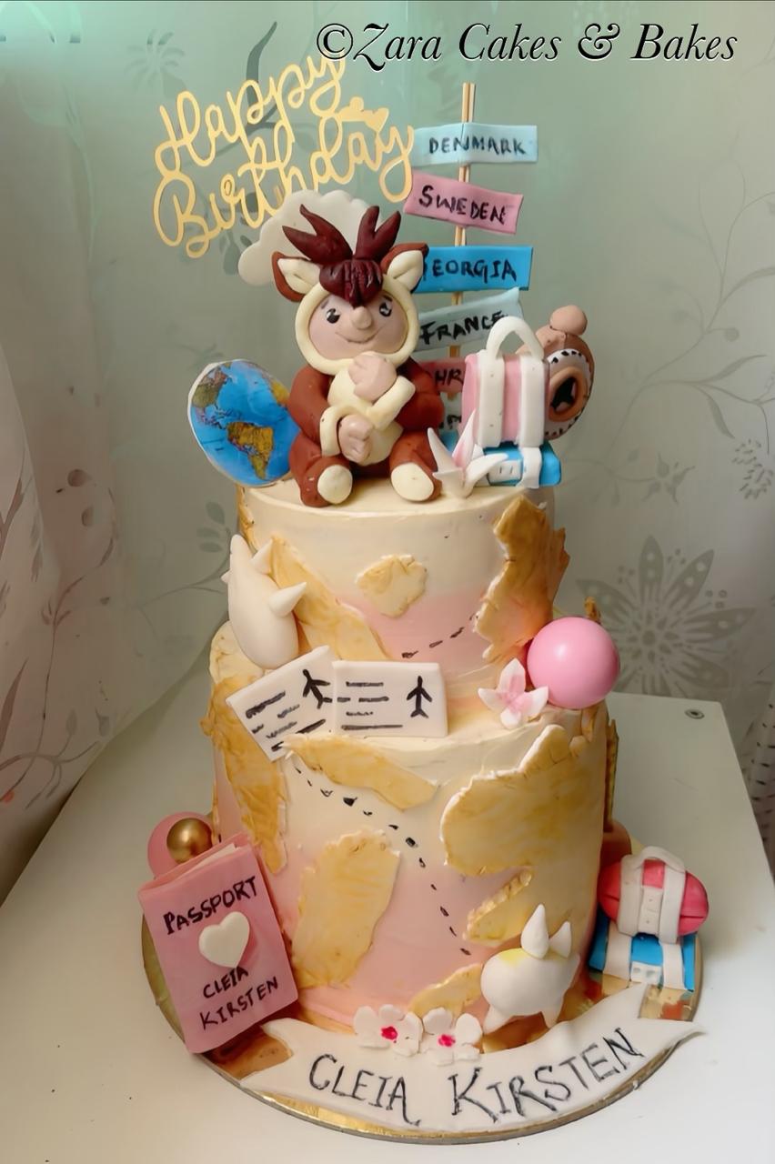 Two-tier world traveler birthday cake with fondant character, painted map, passport, and travel decorations