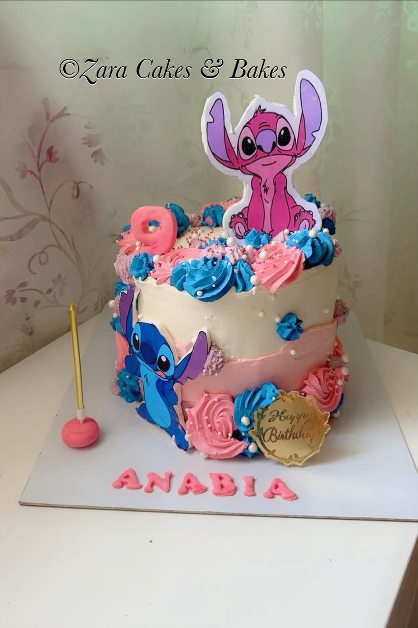 Pink and blue Lilo and Stitch themed birthday cake with Angel and Stitch toppers and buttercream rosettes