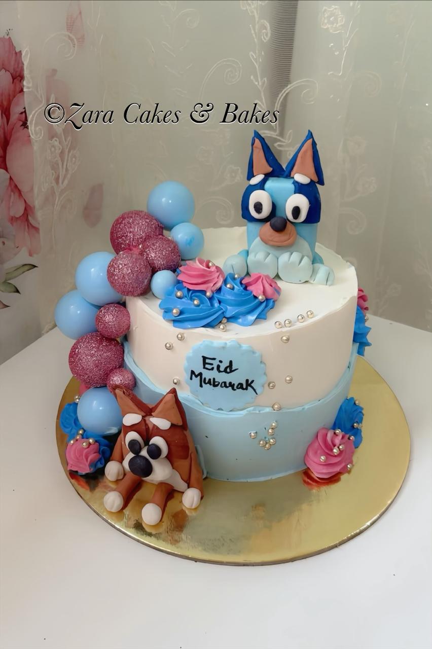 Bluey and Bingo themed Eid Mubarak cake with blue and pink buttercream and fondant balloons