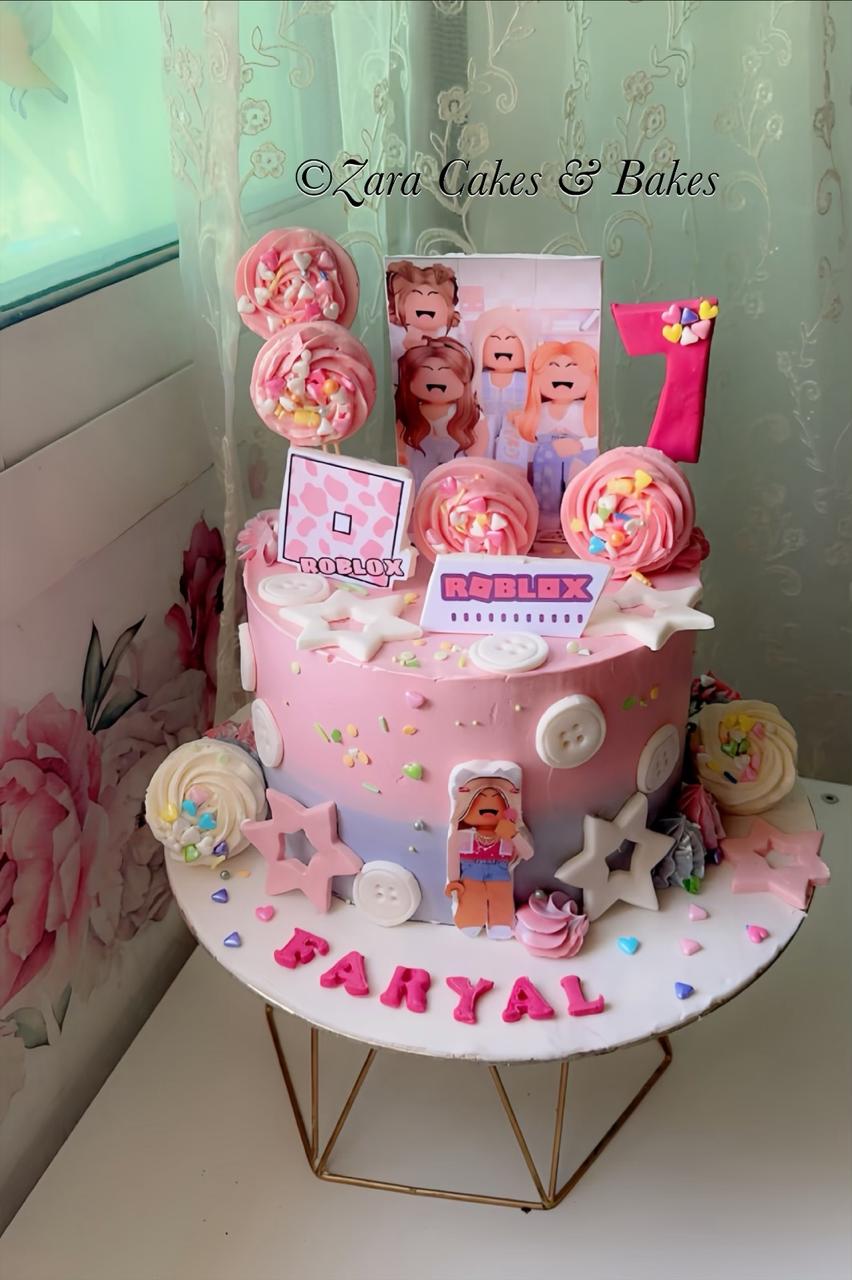 Pink ombre Roblox birthday cake with meringues, fondant buttons, and custom character toppers