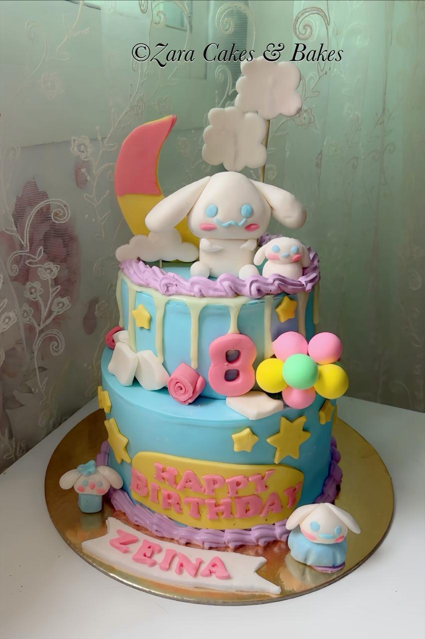 Two-tier Cinnamoroll themed birthday cake with blue fondant, moon topper, and pastel balloons