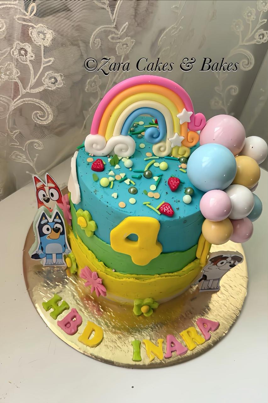 Colorful Bluey themed rainbow birthday cake with fondant characters and balloons for a 4th birthday celebration