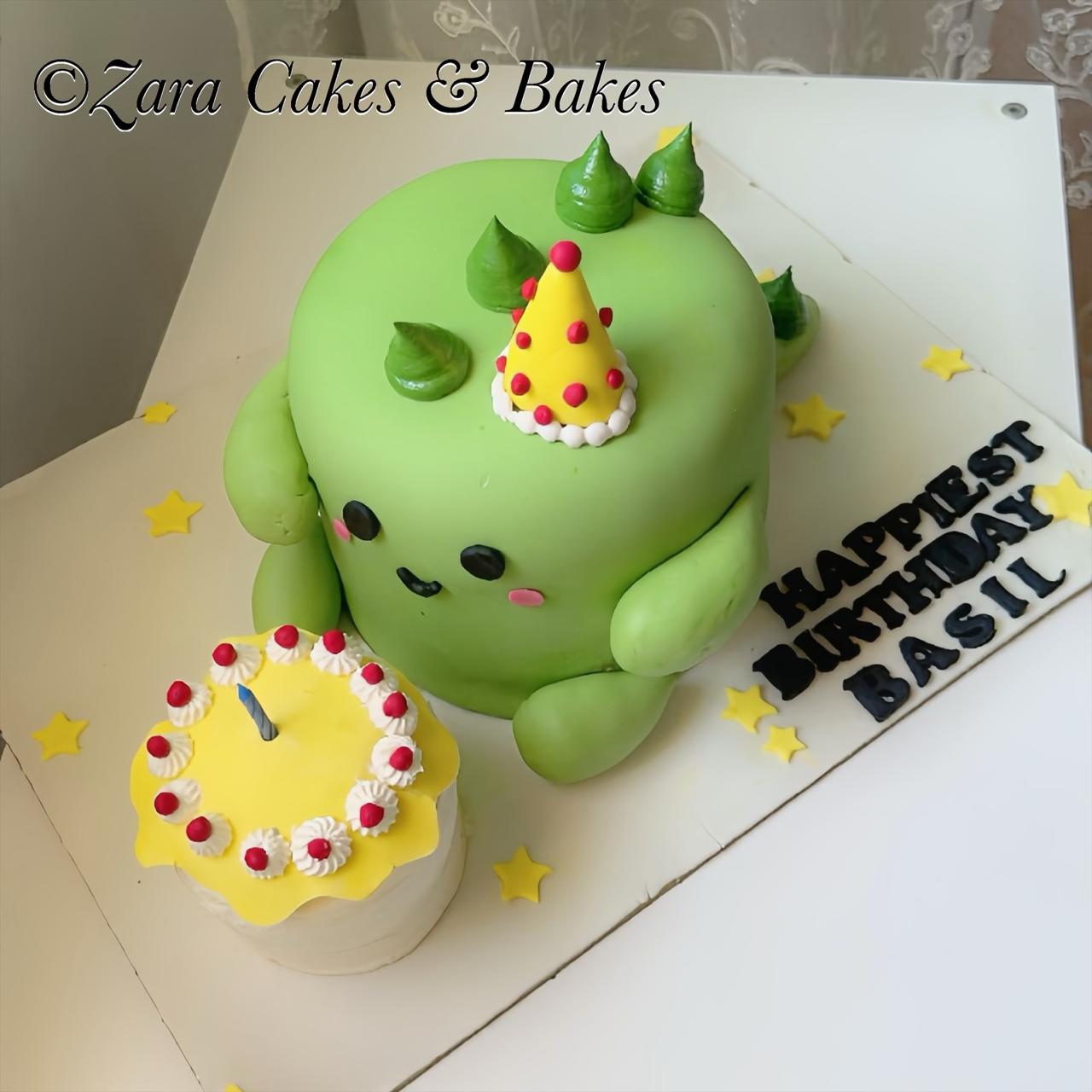 Green dinosaur shaped birthday cake with fondant face and yellow polka dot hat for Basil