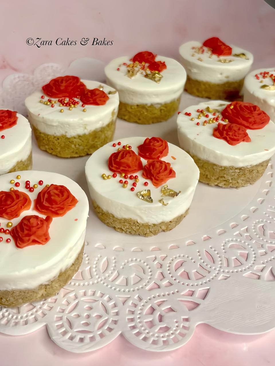 Mini cheesecakes with red rose decorations and gold leaf on a white lace doily