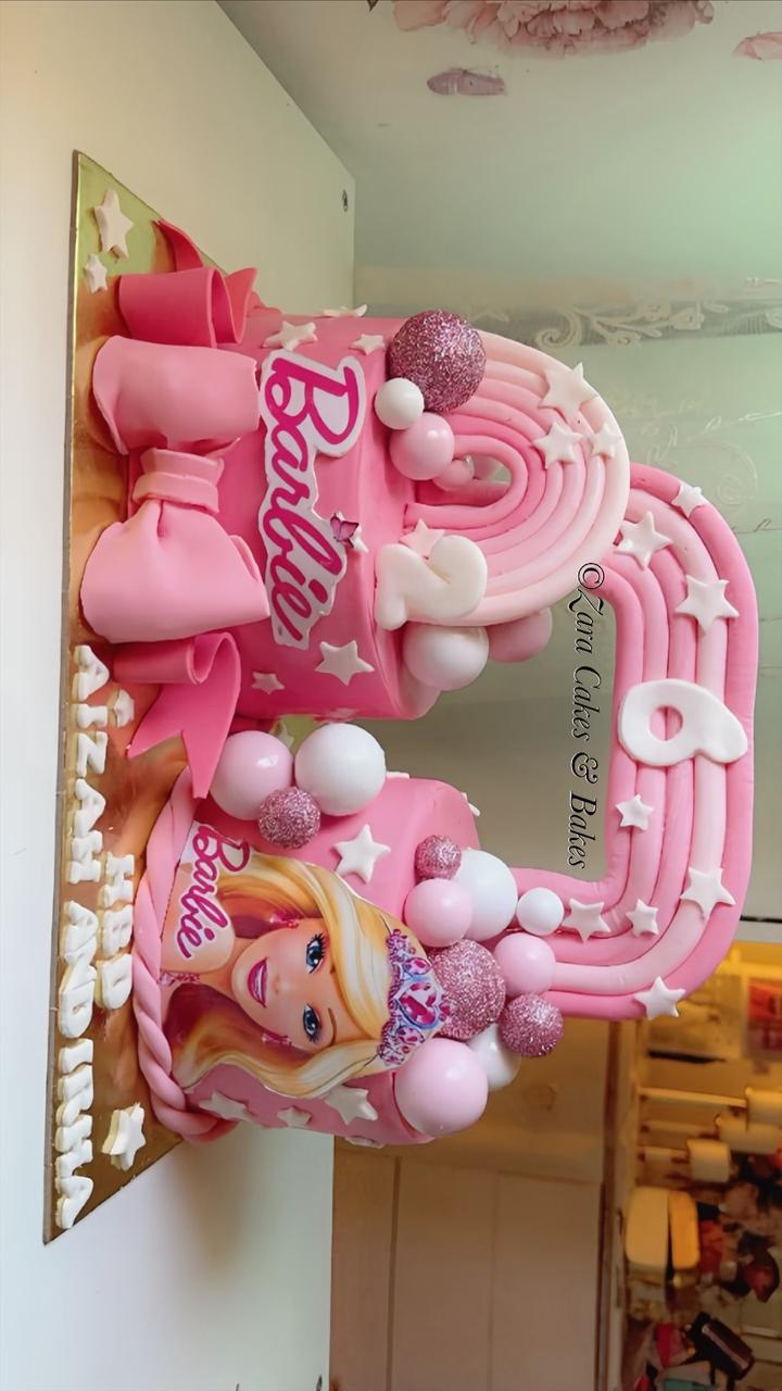 Pink Barbie themed 6th birthday cake with rainbow number, fondant bow, and glitter balls