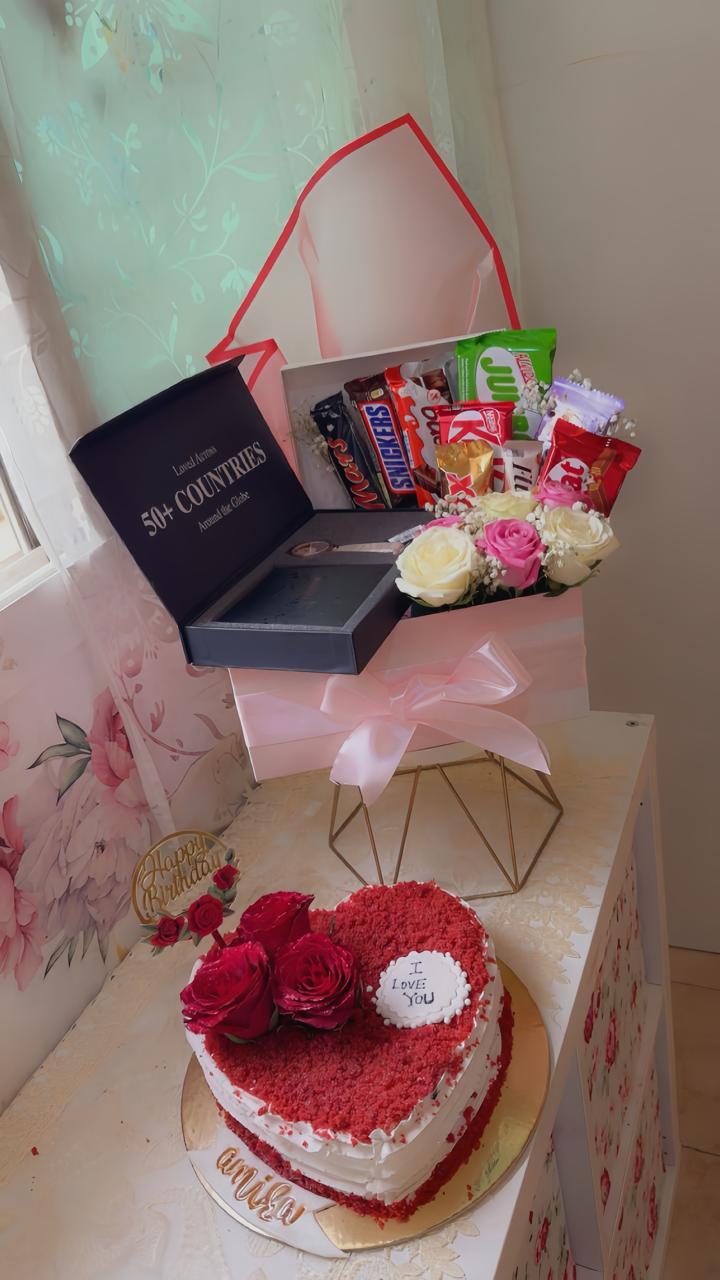 Heart-shaped red velvet birthday cake with fresh roses and luxury chocolate gift box from Zara Cakes Riyadh.
