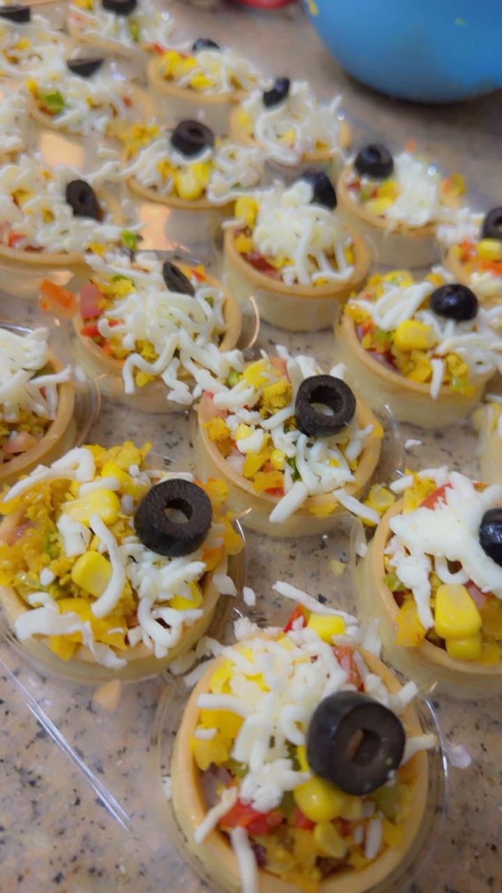 Mini savory vegetable tartlets topped with cheese and olives from Zara Cakes Riyadh