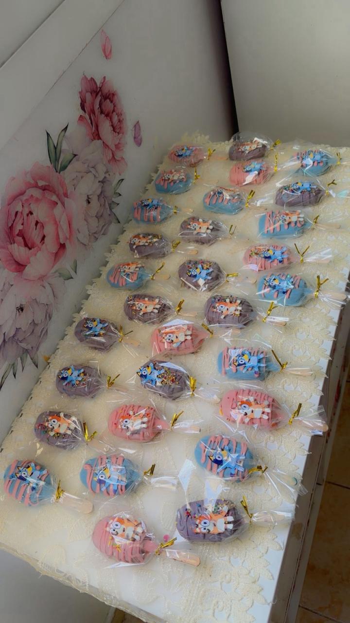 Colorful Paw Patrol cake pops in pink, blue, and purple for kids birthday parties