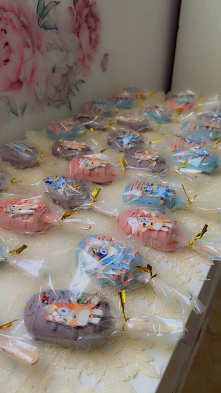 Colorful Bluey character cake pops in pink blue and purple wrapped for party favors