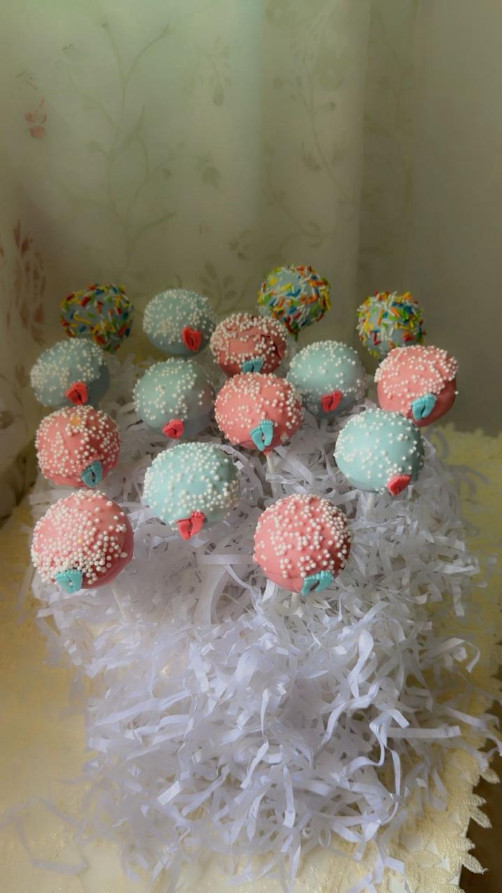 Delicious pastel cake pops bouquet with pink and blue decorations for baby shower parties