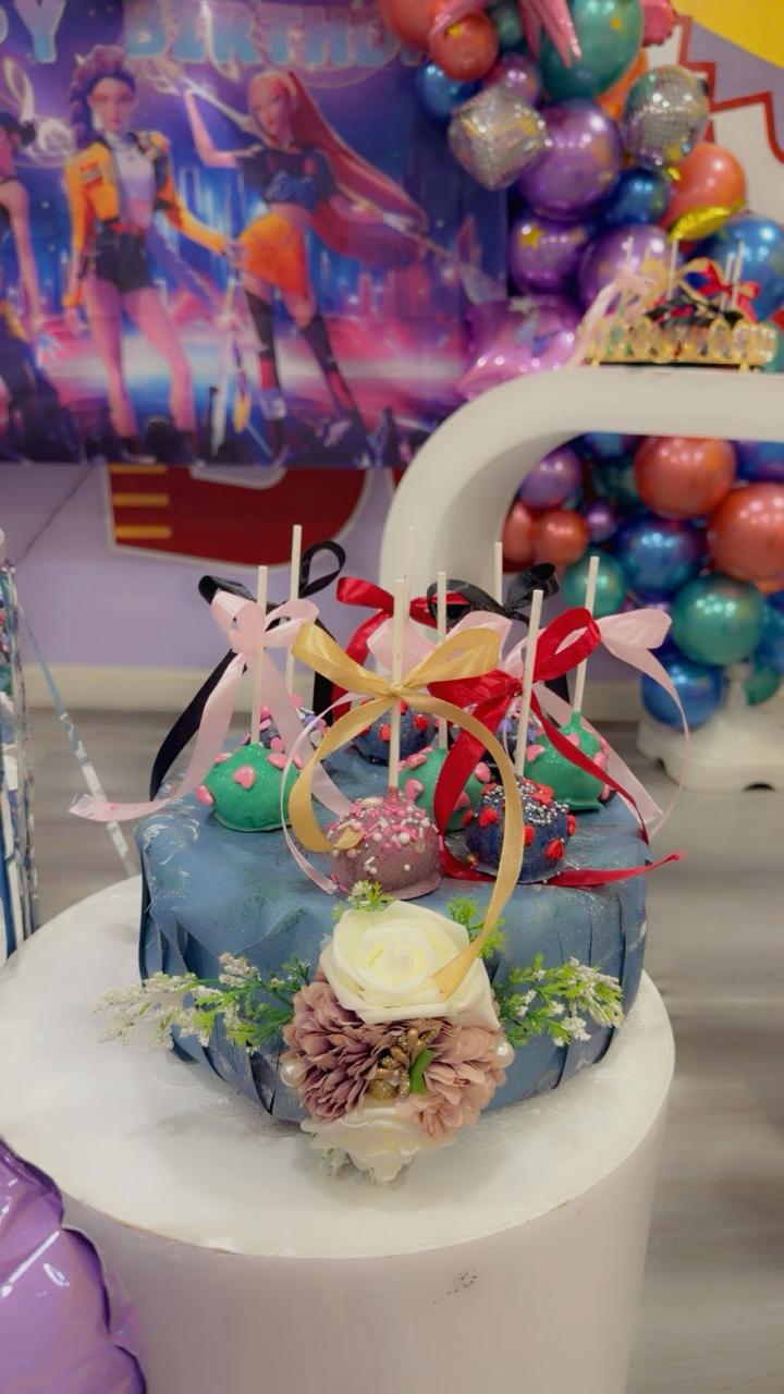Blue gift hamper with cake pops and flowers from Zara Cakes Riyadh bakery.